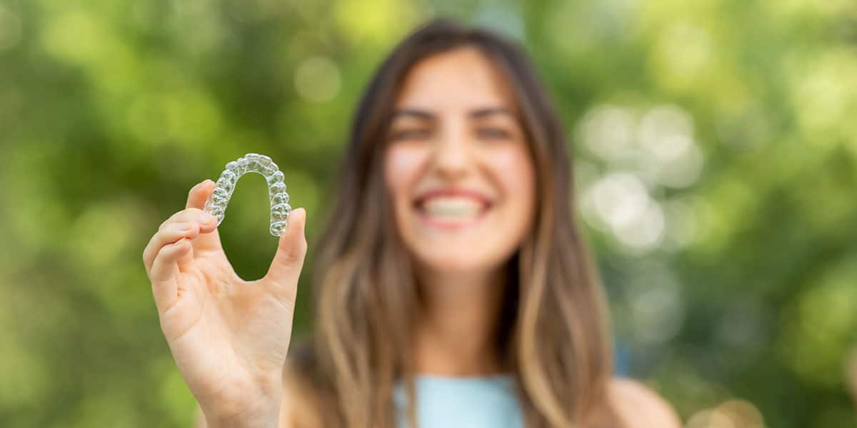 woman holding an invisalign appliance